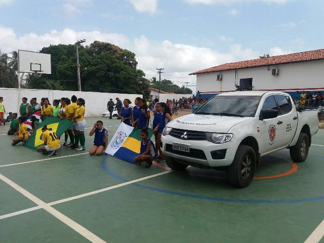 Estudantes na quadra, junto à viatura policial, durante a solenidade de inauguração